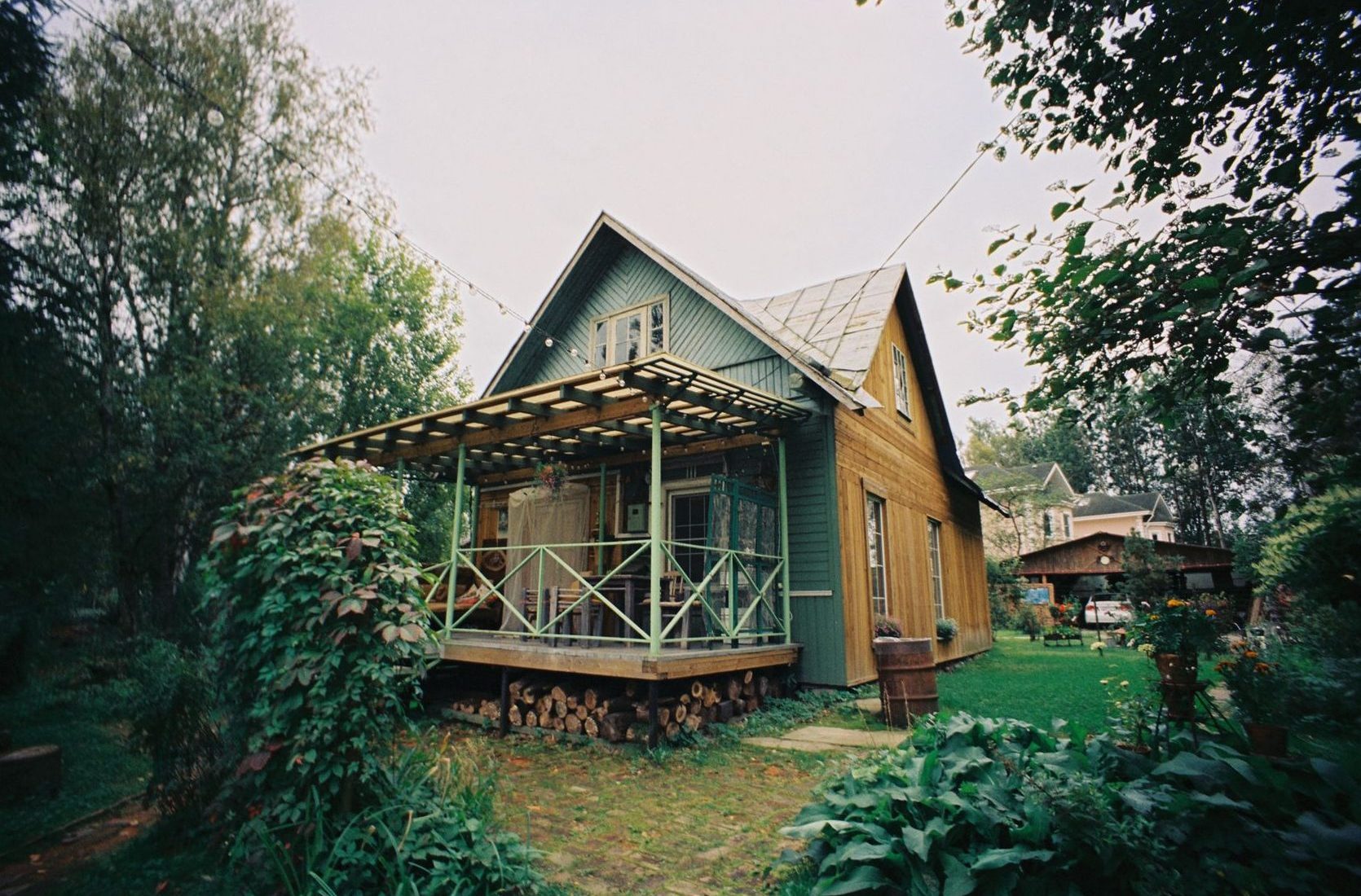 Maison en bois avec véranda dans un jardin arboré